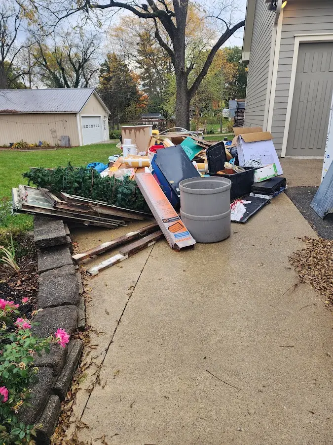 Dumpster being loaded with debris for Estate Cleanout Dumpster Rental in Cottage Grove